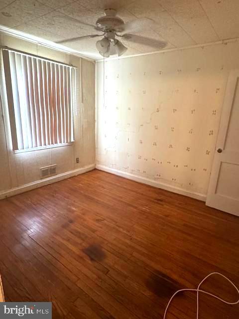3582 Dudley Avenue Baltimore, MD 21213 - Photo 7 of 13 an empty room with wooden floor and windows