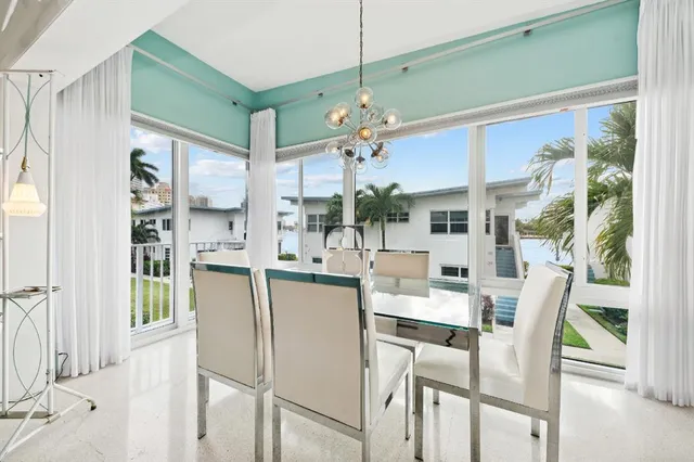a dining room with furniture and a large window