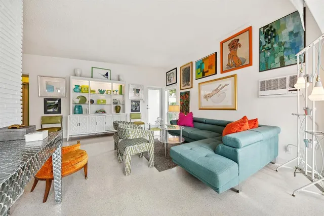 a living room with furniture and paintings on the wall