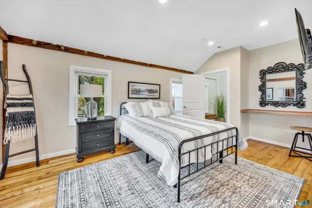 a bedroom with a bed and a view of living room