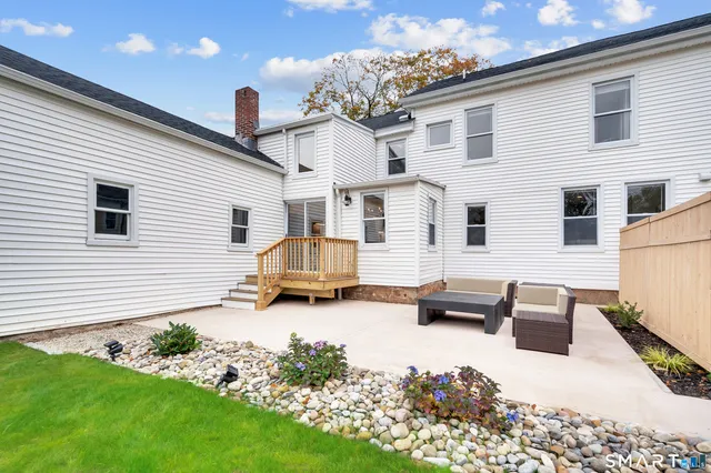 a view of a white house with yard in front of it