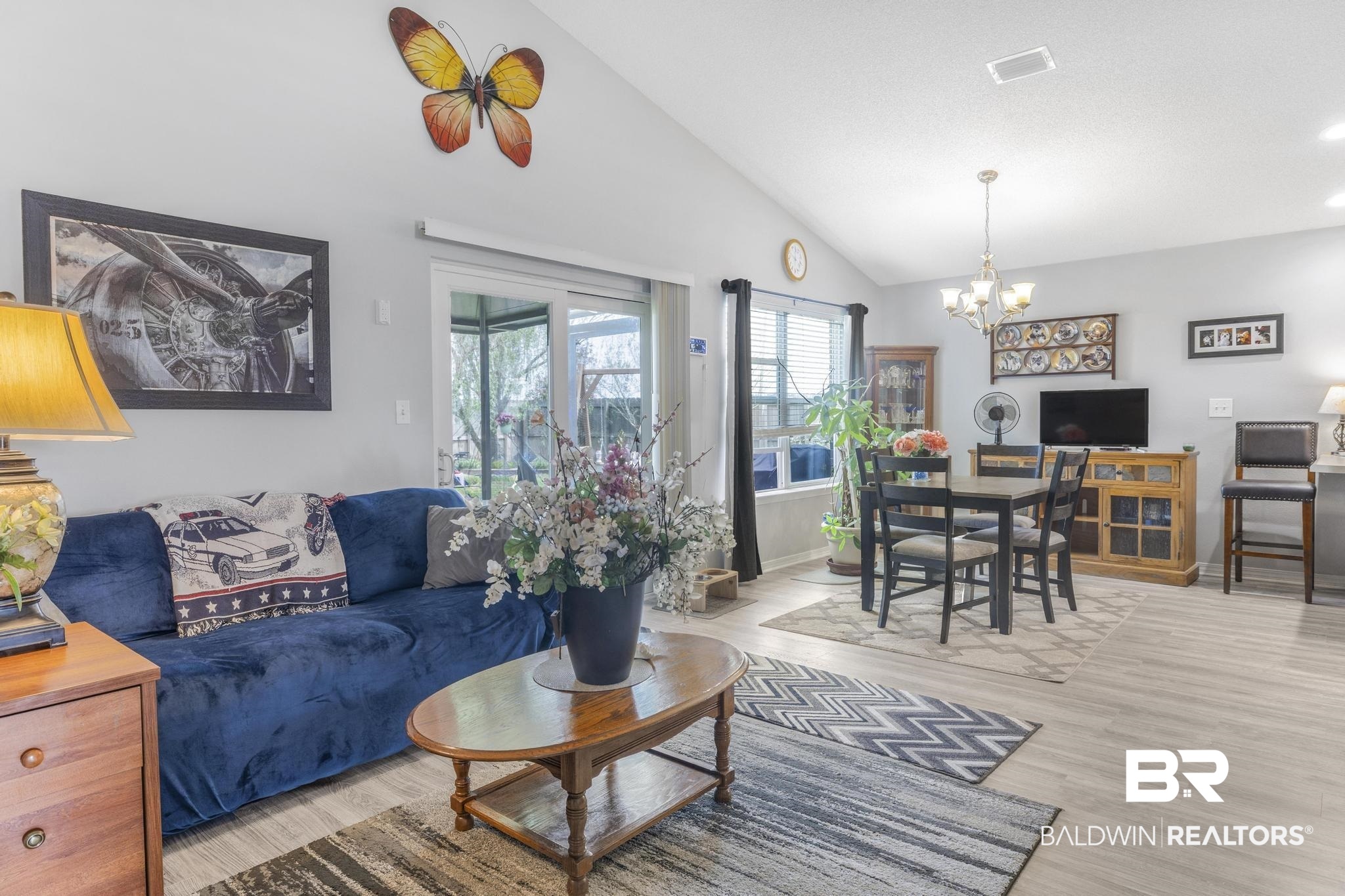 16545 Cold Mill Loop Foley, AL 36535 - Photo 5 of 48 Living area featuring lofted ceiling, baseboards, light wood-style floors, visible vents, and a notable chandelier