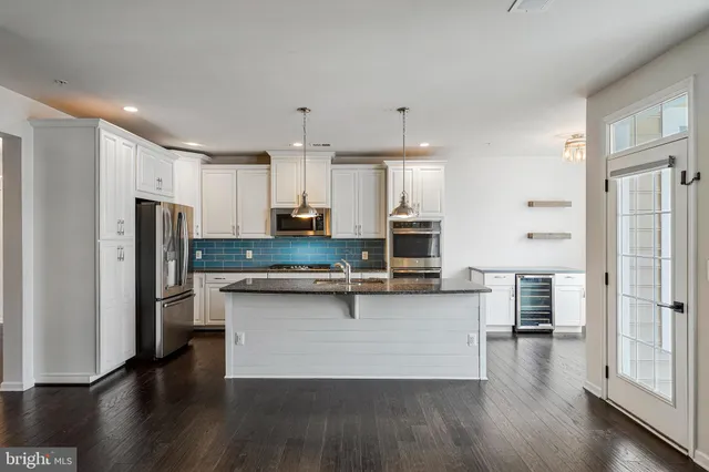 a view of kitchen with stainless steel appliances refrigerator stove microwave and cabinets