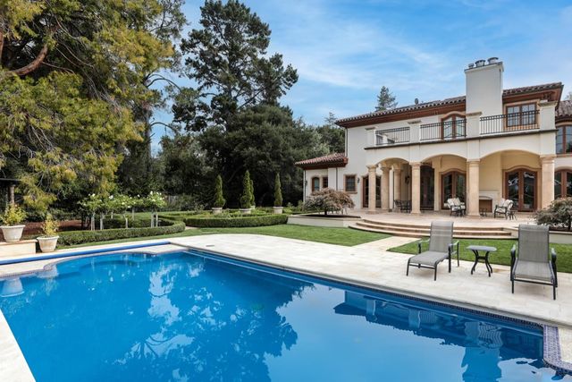 a view of a house with pool and chairs