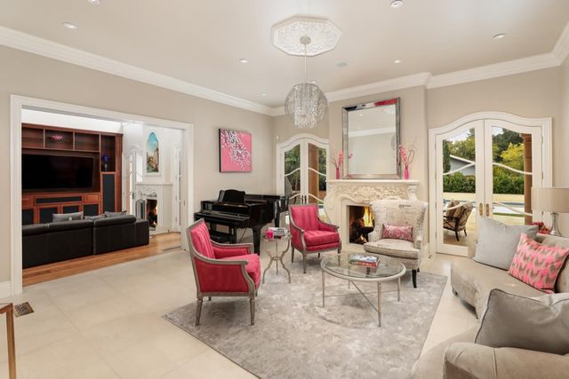 a living room with furniture a flat screen tv and floor to ceiling window
