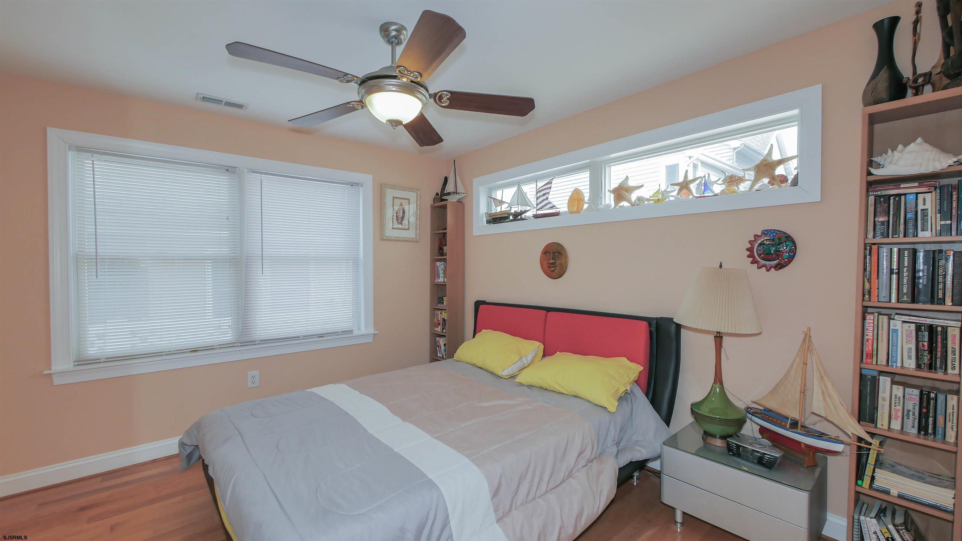 229 8th Street North Brigantine, NJ 08203 - Photo 33 of 42 a bedroom with a large bed and a chandelier