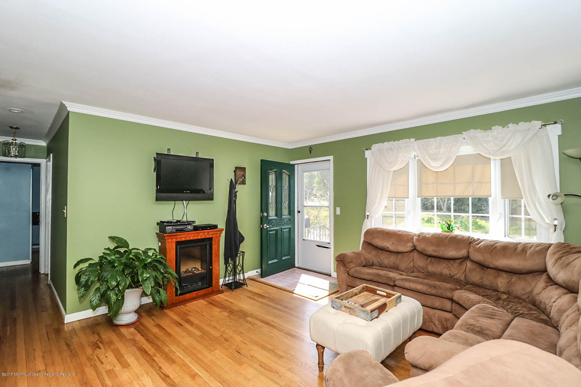 349 Middle Road Hazlet, NJ 07730 - Photo 24 of 38 a living room with furniture a flat screen tv and a floor to ceiling window