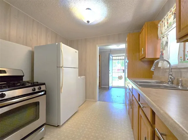 a kitchen with stainless steel appliances a refrigerator sink and stove