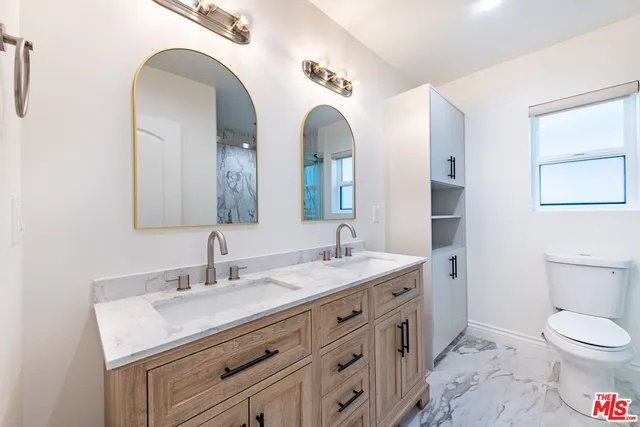 a bathroom with a double vanity sink and a mirror