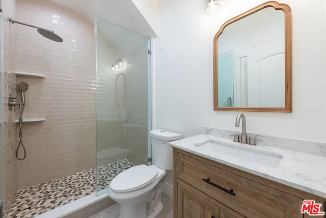 a bathroom with a sink a toilet and shower