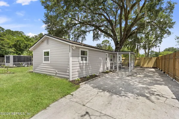 a view of a backyard with a large tree