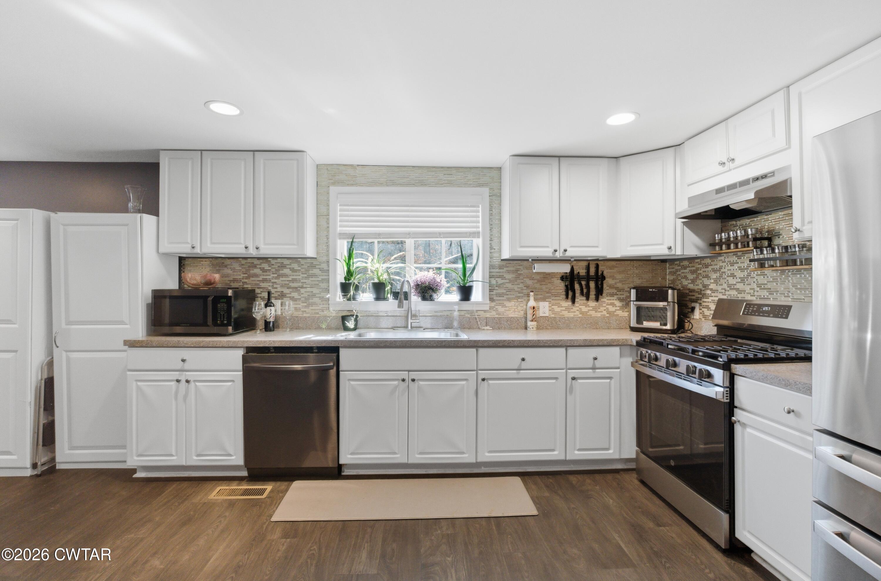 390 Memory Lane Henderson, TN 38340 - Photo 15 of 24 a kitchen with stainless steel appliances granite countertop a stove a sink and a refrigerator