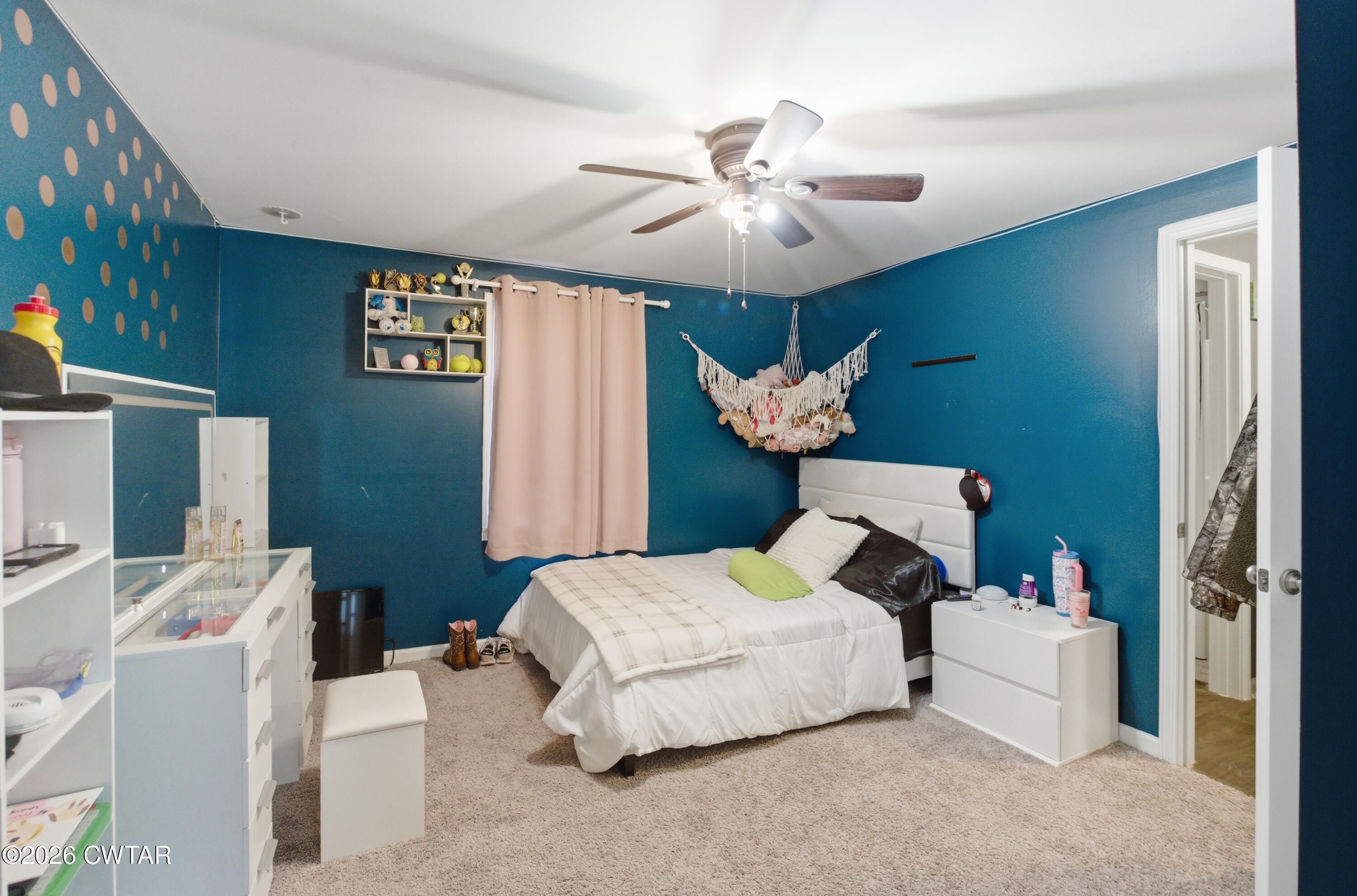 390 Memory Lane Henderson, TN 38340 - Photo 18 of 24 a bedroom with a bed and a chandelier