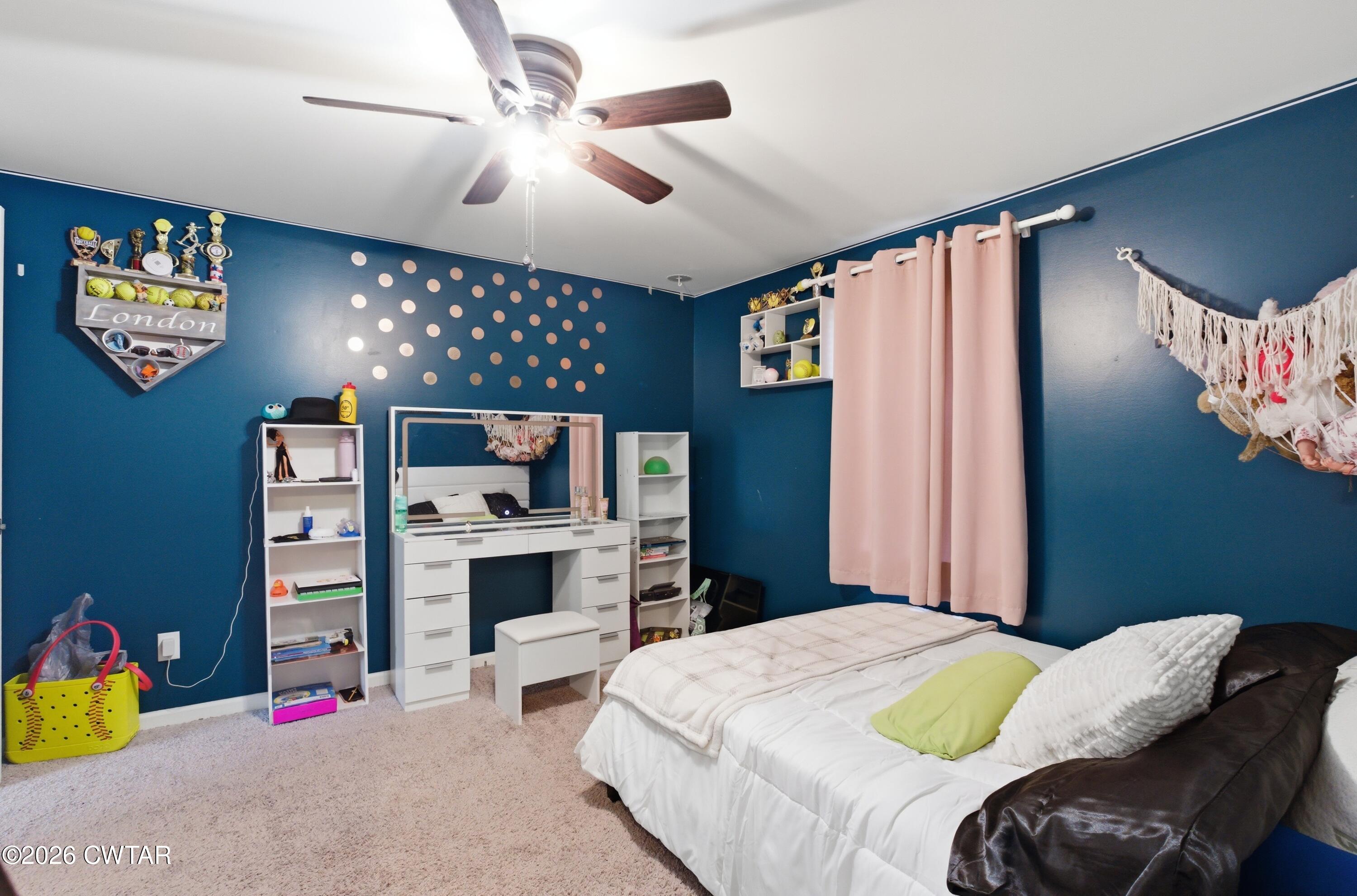 390 Memory Lane Henderson, TN 38340 - Photo 7 of 24 a bedroom with a bed dresser and a chandelier