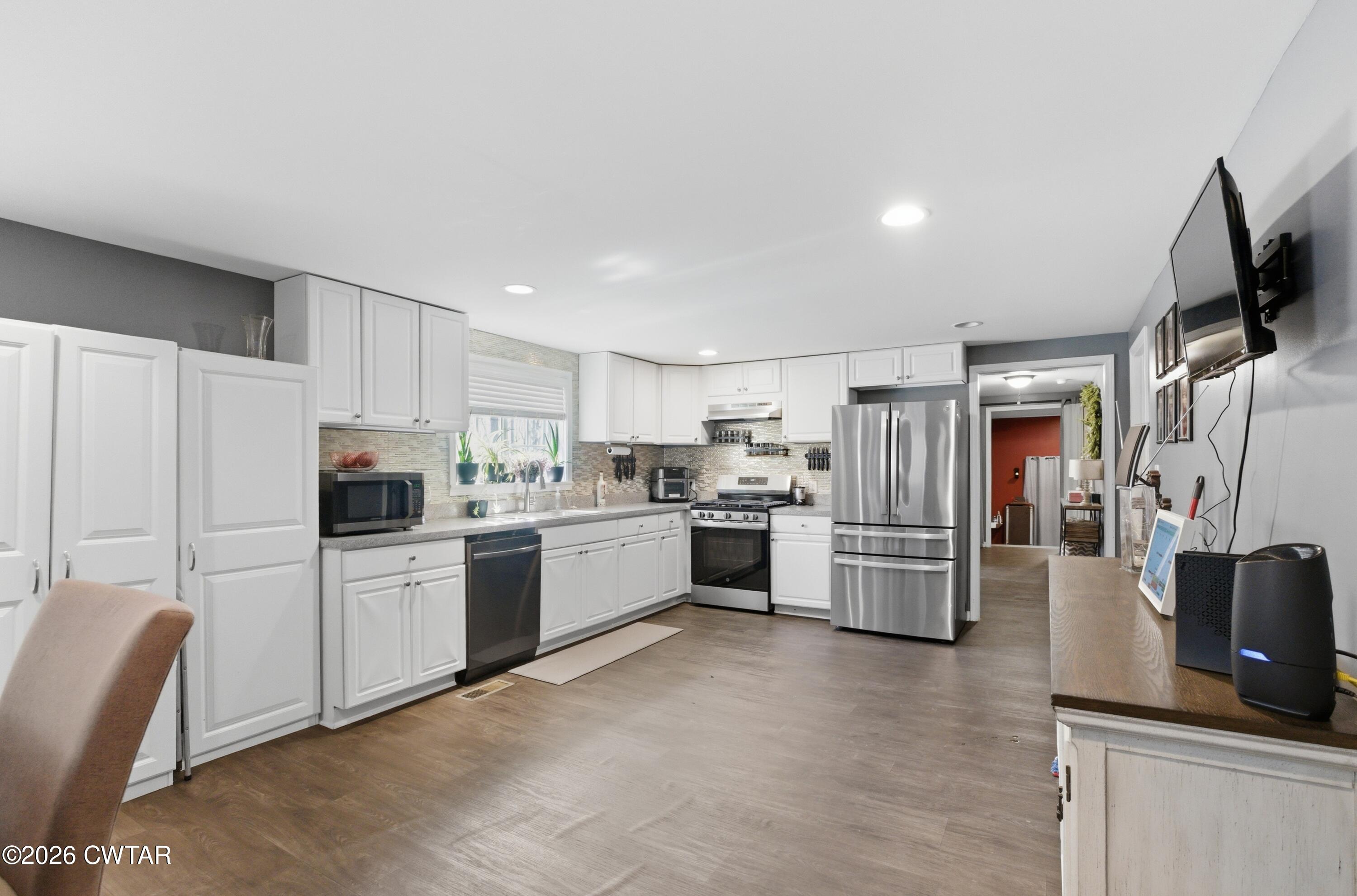 390 Memory Lane Henderson, TN 38340 - Photo 10 of 24 a kitchen with refrigerator a microwave a stove and white cabinets