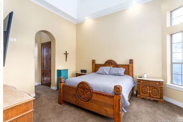 a bedroom with a bed and a dresser next to a window