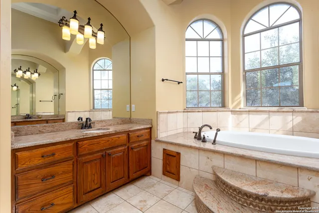 a bathroom with a granite countertop sink a large mirror and a window