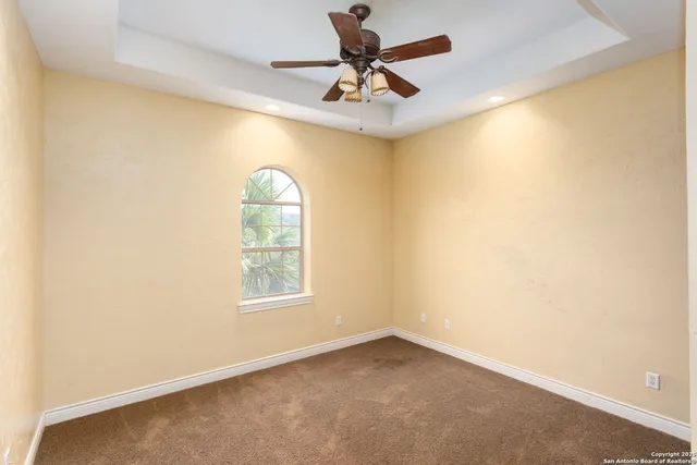 an empty room with a window and a fan
