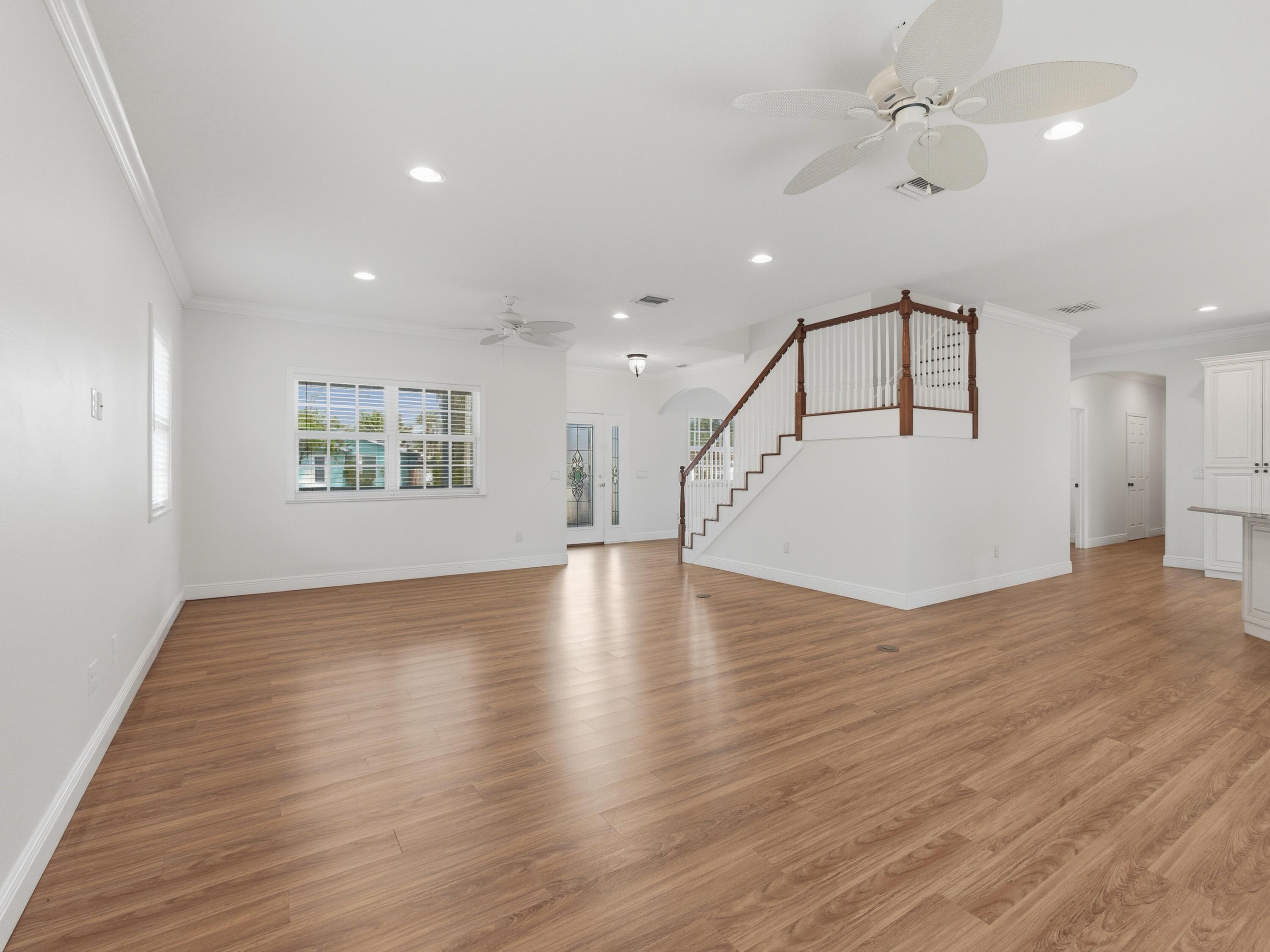 9322 Southeast Athena Street Hobe Sound, FL 33455 - Photo 14 of 68 a view of an empty room with wooden floor and a ceiling fan