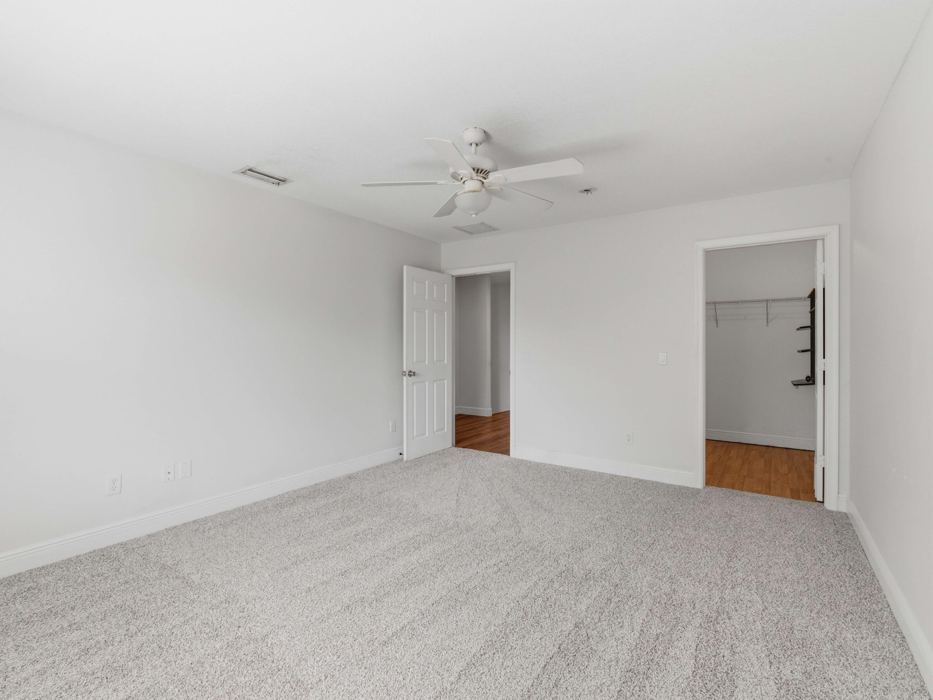9322 Southeast Athena Street Hobe Sound, FL 33455 - Photo 45 of 68 a view of an empty room with a ceiling fan