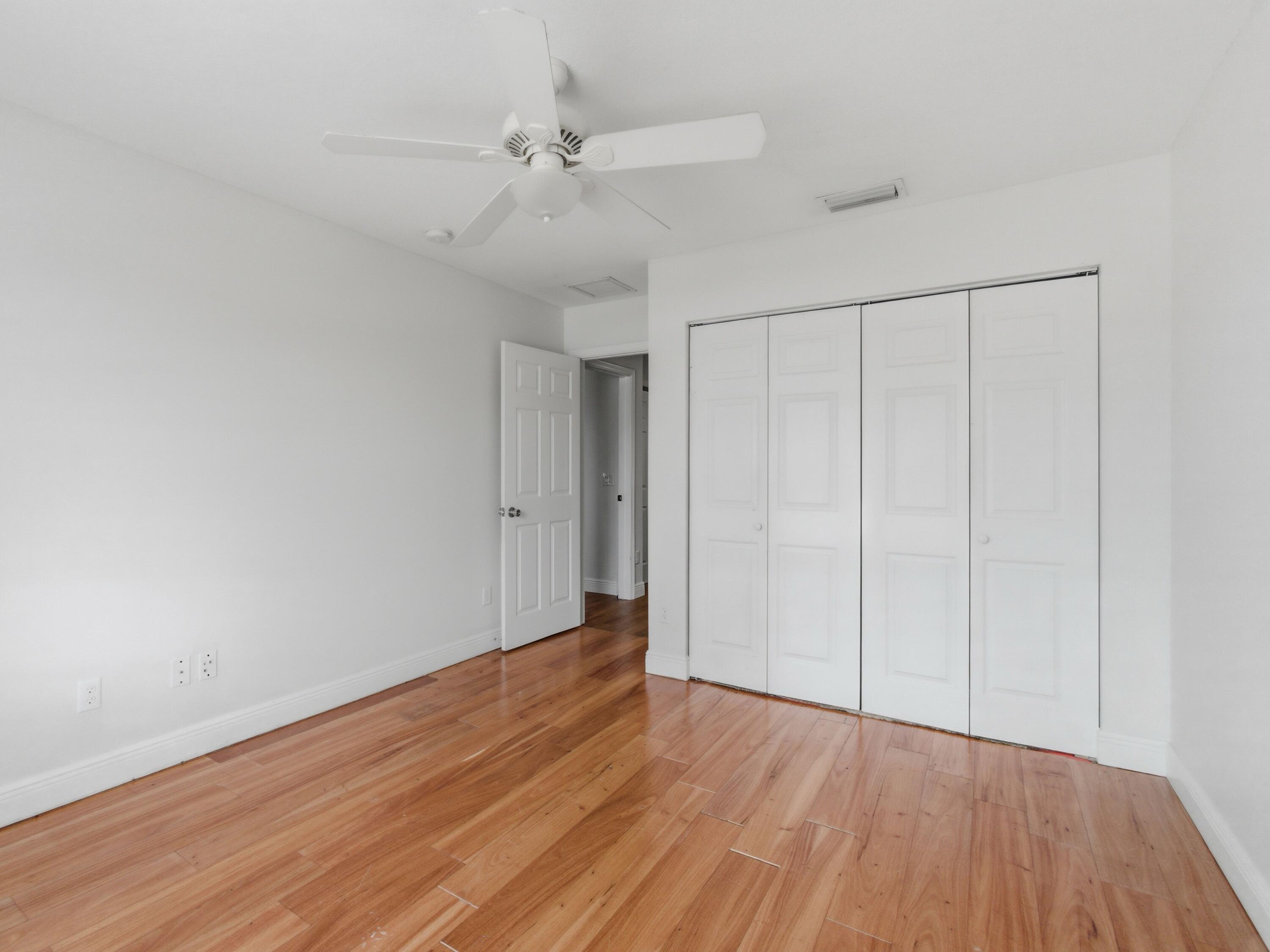 9322 Southeast Athena Street Hobe Sound, FL 33455 - Photo 48 of 68 a view of an empty room with wooden floor