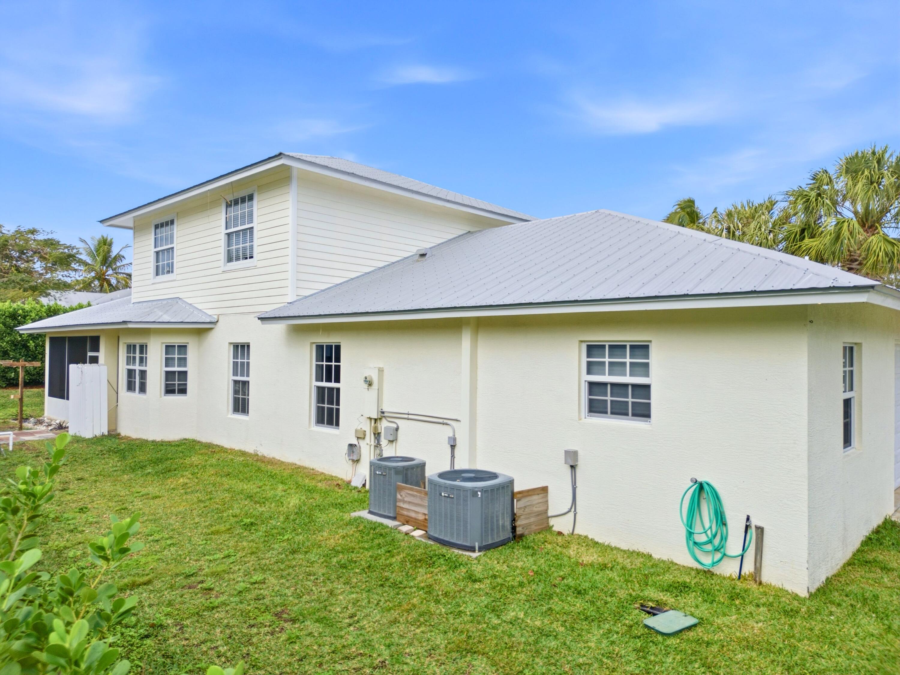 9322 Southeast Athena Street Hobe Sound, FL 33455 - Photo 53 of 68 a front view of a house with garden