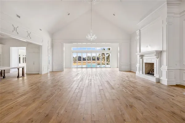 a view of a livingroom with wooden floor a fireplace and window