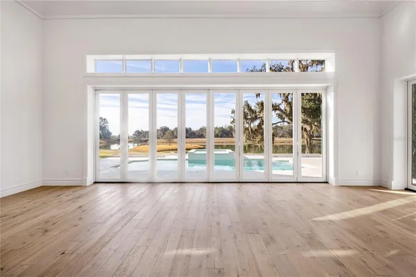 an empty room with wooden floor and door
