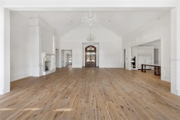 a view of a big room with wooden floor and windows