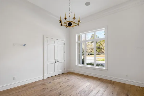 a view of a room with a cabinet and a chandelier fan