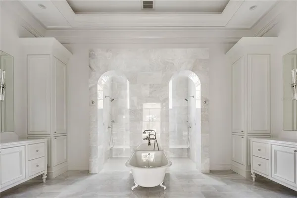 a spacious bathroom with a double vanity sink a mirror and a bathtub