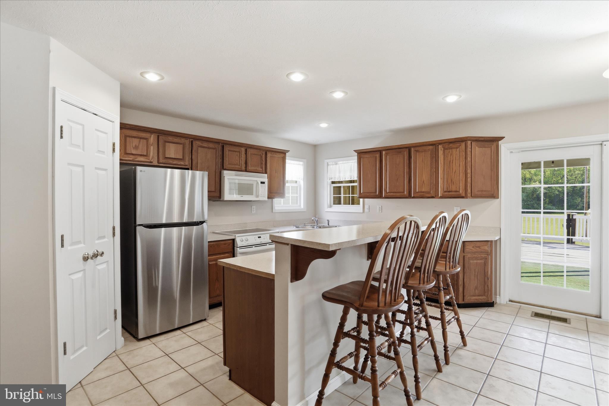 13605 McKenzie Tower Road Southwest Cumberland, MD 21502 - Photo 12 of 63 a kitchen with stainless steel appliances granite countertop a refrigerator a stove a sink a dining table and chairs with wooden floor