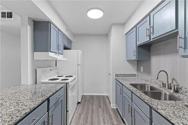 a kitchen with stainless steel appliances granite countertop a sink stove and cabinets