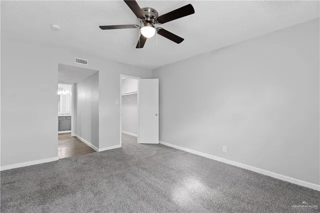 an empty room with chandelier fan