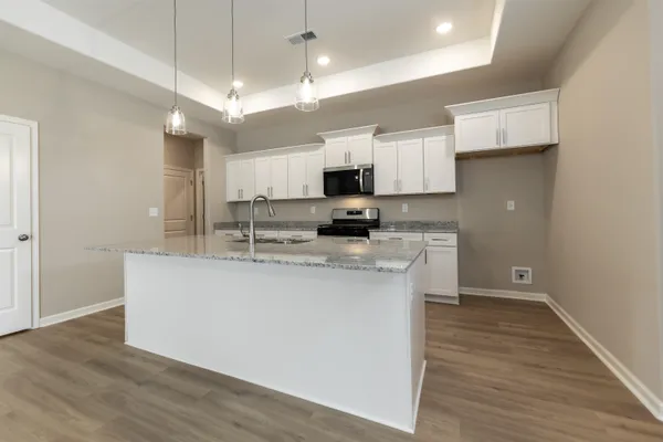 a kitchen with kitchen island a sink and a stove top oven