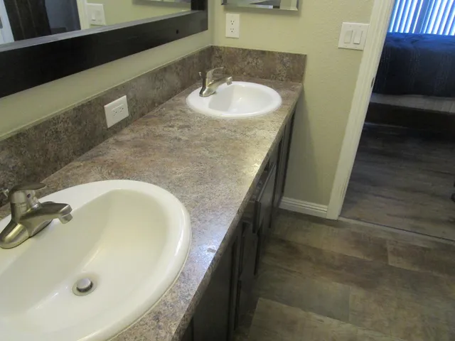 a bathroom with a granite countertop sink and a tub