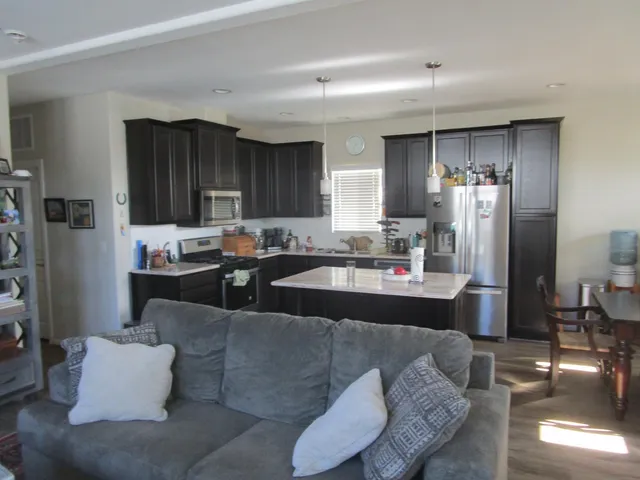 a living room with stainless steel appliances kitchen island granite countertop furniture and a view of kitchen