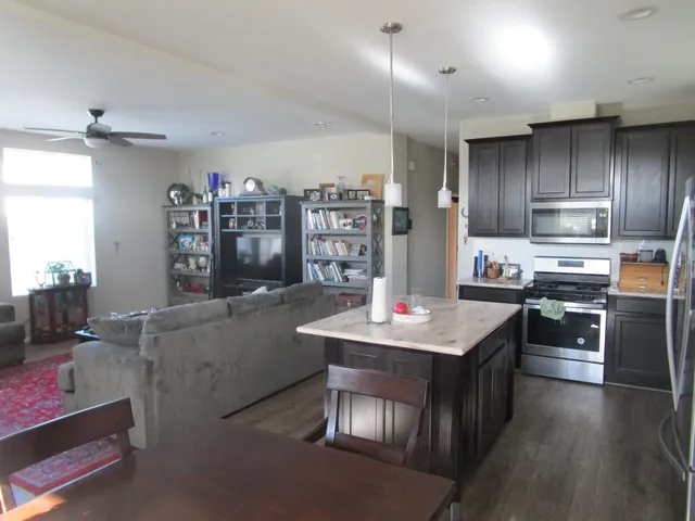 a kitchen with stainless steel appliances granite countertop a sink dishwasher stove refrigerator and cabinets