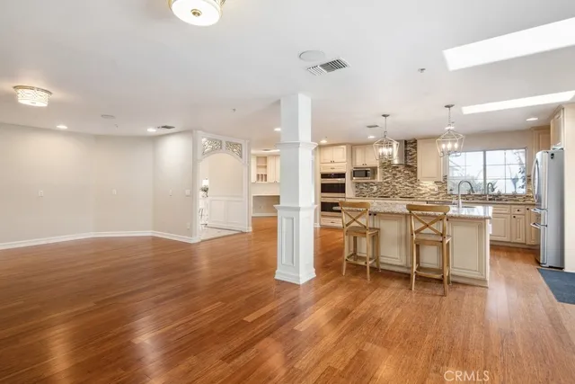 a view of kitchen with refrigerator stove microwave and wooden floor