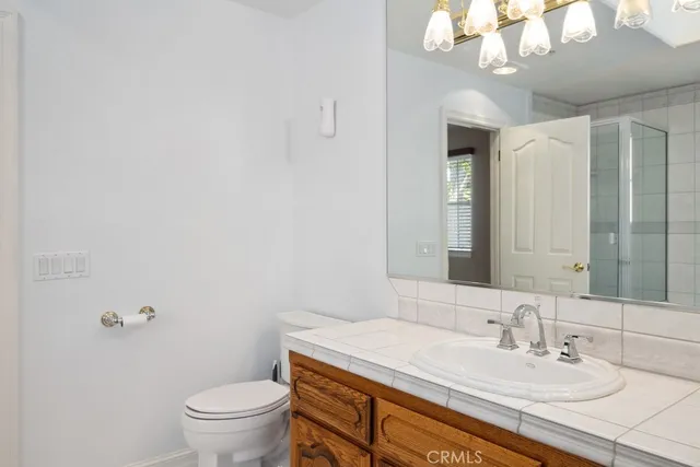 a bathroom with a granite countertop sink a toilet and a mirror