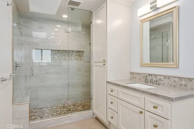 a bathroom with a granite countertop sink mirror and shower