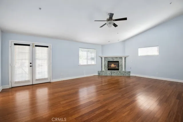 a view of a livingroom with wooden floor and a ceiling fan