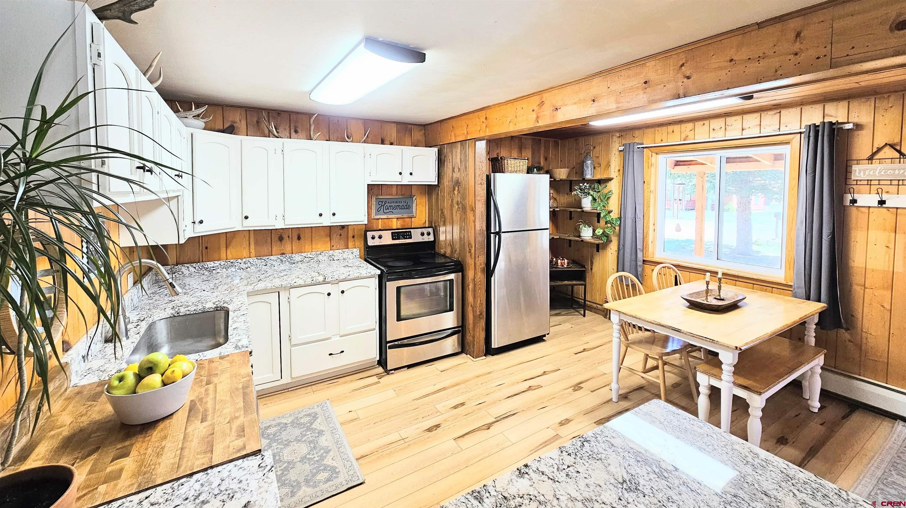 a kitchen with stainless steel appliances kitchen island granite countertop a refrigerator a stove top oven and a sink