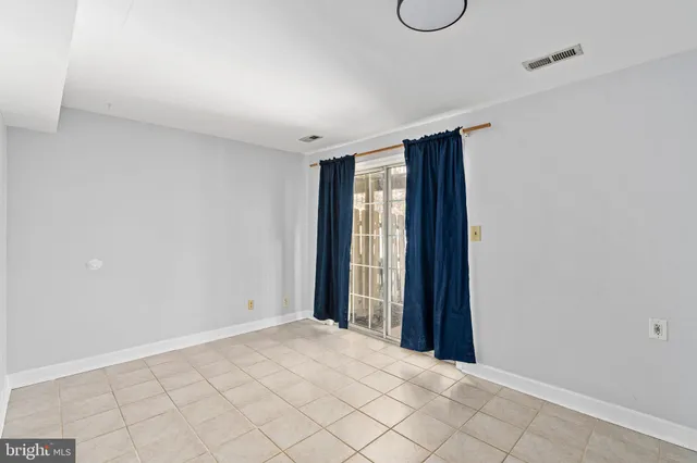 a view of an empty room with wooden floor and chair