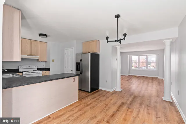 a kitchen with a refrigerator and a stove top oven