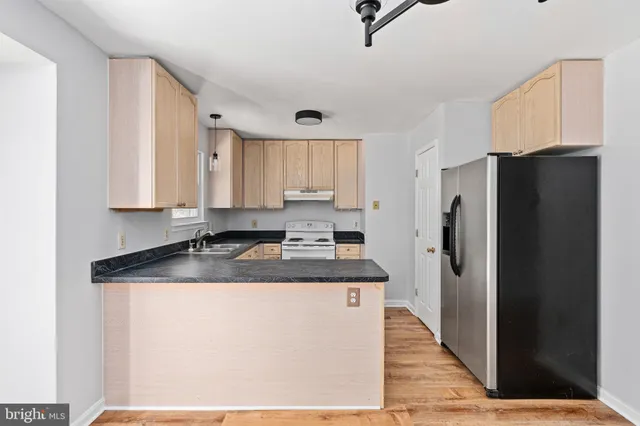 a kitchen with stainless steel appliances granite countertop a refrigerator a sink and dishwasher