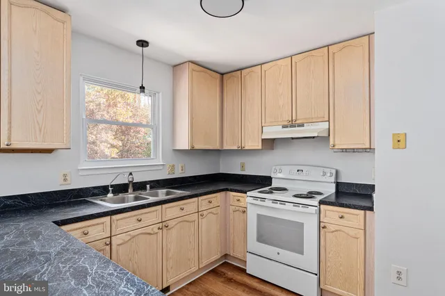 a kitchen with granite countertop white cabinets and white appliances