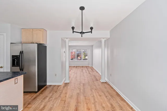 a view of a kitchen with wooden floor refrigerator and a sink