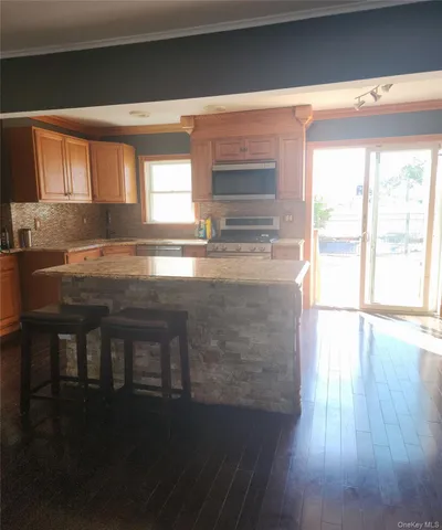 a kitchen with granite countertop a stove a sink and a microwave