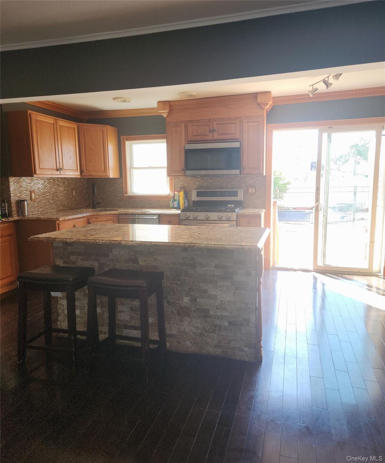 Undisclosed Address West Babylon, NY 11704 - Photo 9 of 12 a kitchen with granite countertop a stove a sink and a microwave